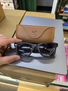 Black Ray-Ban Meta glasses and a brown protective case.